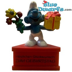 20040: Gift Smurf with present and flowers  - Herzlichen Gluckwunsch zum Geburtstag -  (pedestal) - Schleich - 5,5cm